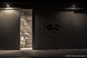 Dimly lit warehouse with open door.