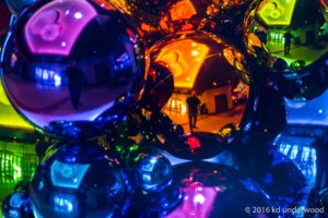 Colorful reflective spheres with silhouetted figure.