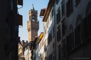 Historic tower viewed from narrow street.