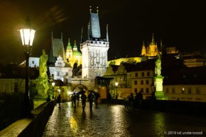 Nighttime view of illuminated historic bridge.