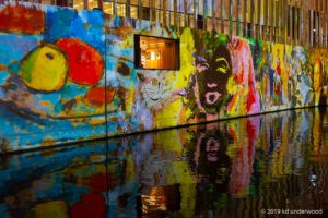 Colorful mural reflecting on water surface.