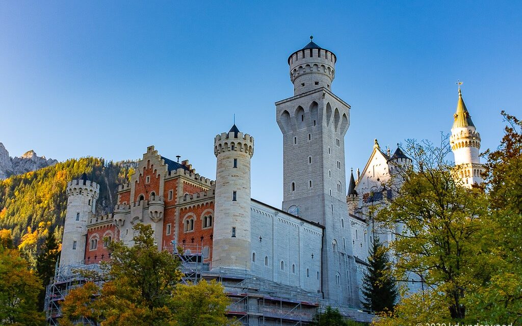 Majestic castle surrounded by trees and mountains.